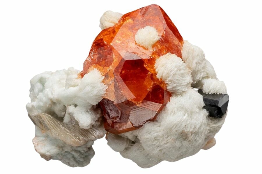 A huge beautiful garnet sitting on a pretty white mineral