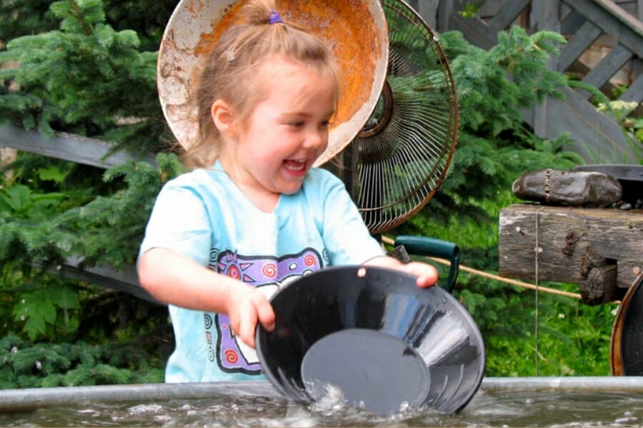 A girl happily panning for gold at Indian Valley Mine