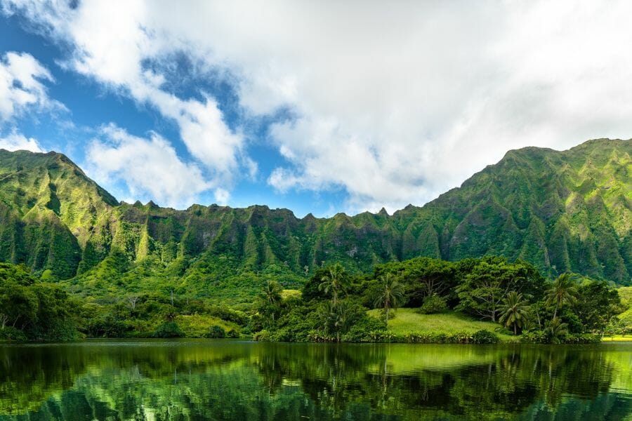 A scenic view of the Koolau Range with its rich green trees and grass and a lake at its foot