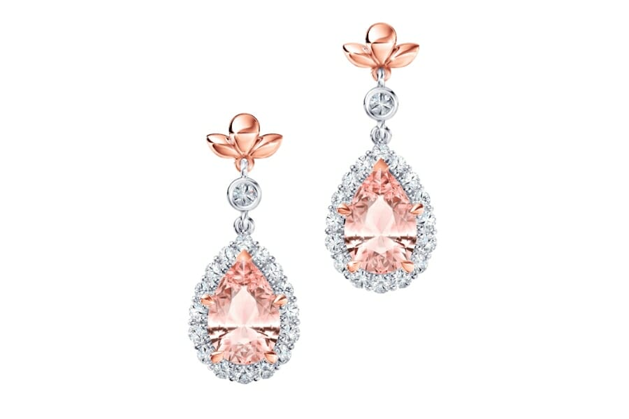 A pair of dangling earrings with pear-shaped Morganite as center stone with small, white Diamonds surrounding it
