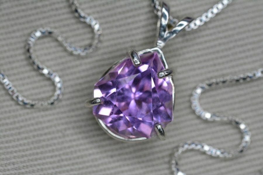 A mesmerizing purple kunzite pendant necklace with a silver chain