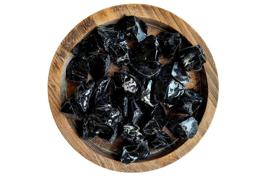 A bunch of shiny Black Obsidian on a wooden container