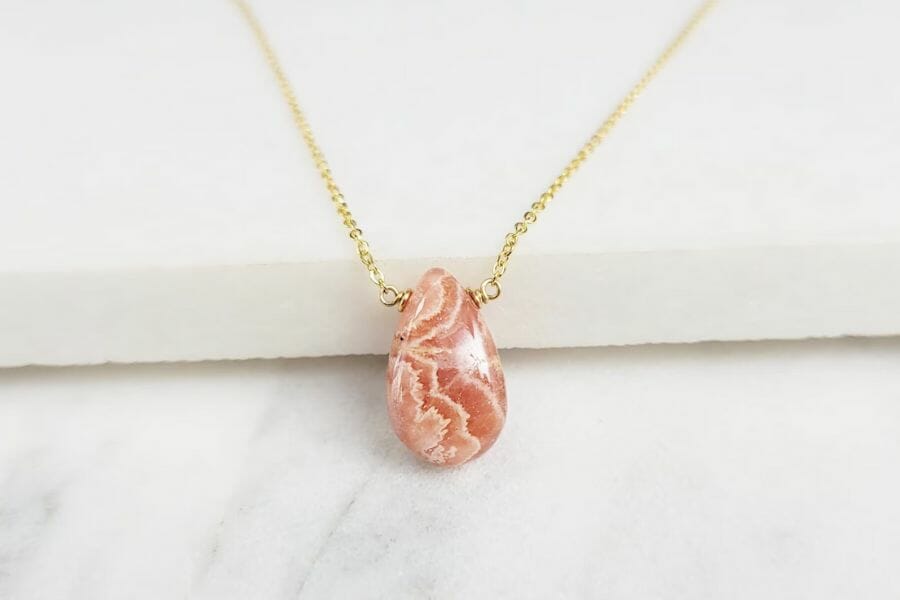 A dainty rhodonite necklace with a gold chain