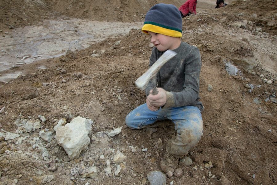 A kid rockhounding for minerals at the Royal Peacock Opal Mine