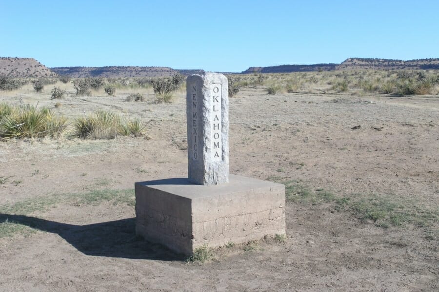 Tri-state marker of New Mexico, Oklahoma, and Colorado where there are petrified wood scattered around the area