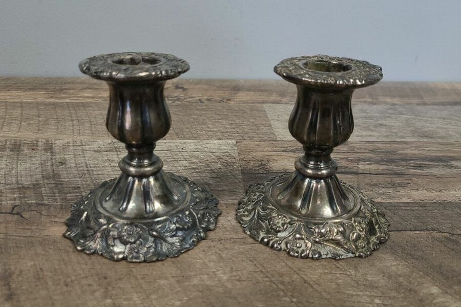 A timeless pair of antimony candleholders with intricate details at the bottom