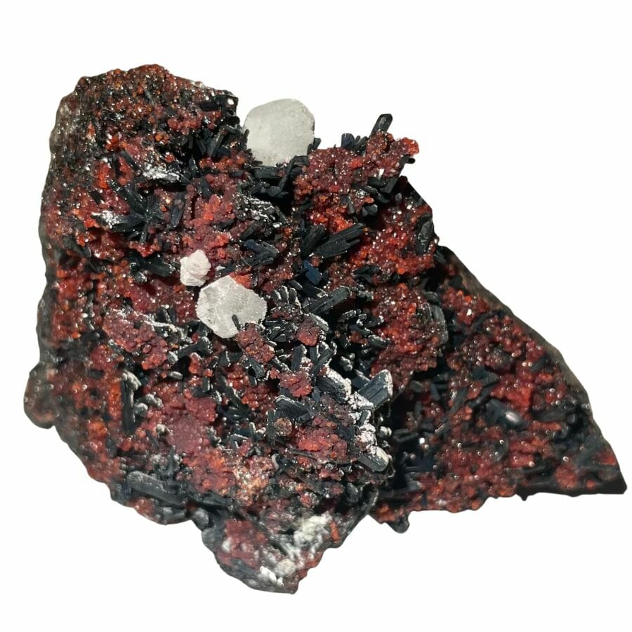 A brilliant garnet gemstone with white and black crystals
