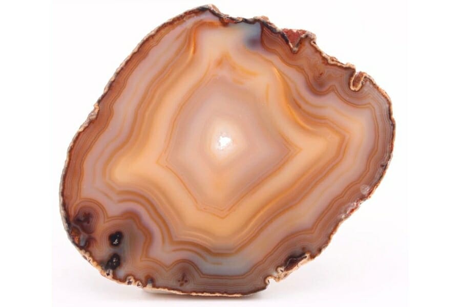Banded Agate sliced in half to reveal orange, yellow, and white-colored bands