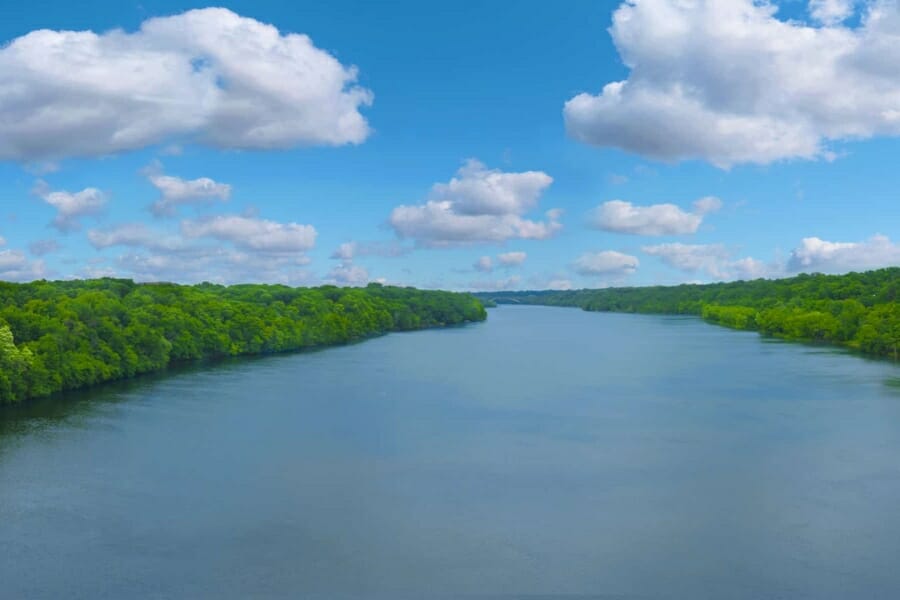 Long winding river of the Mississippi River in between forests of lush green trees