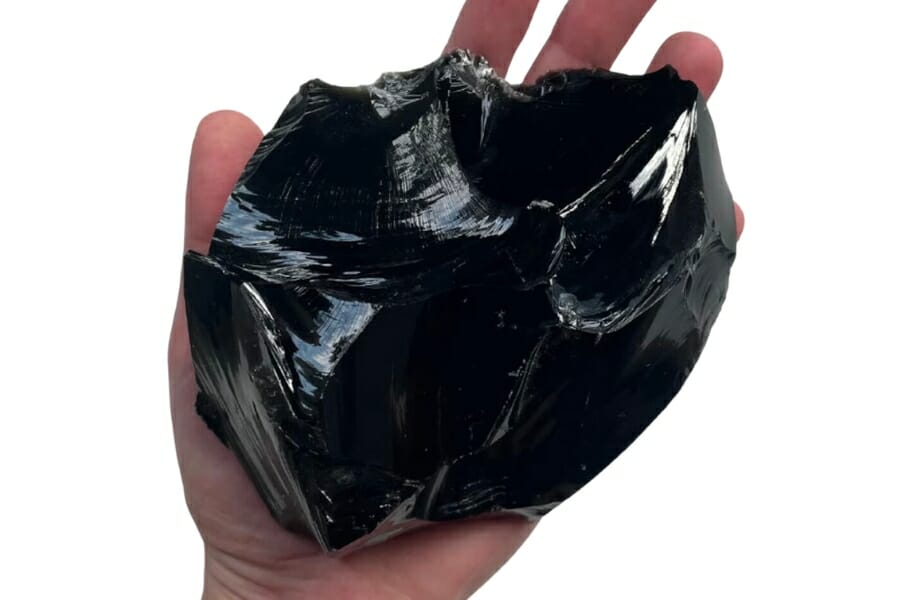 Stunning glassy black raw Obsidian held out by a hand