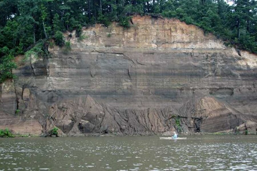 A beautiful cliff formation with lush trees over the Ouachita River