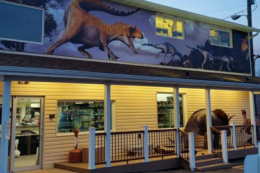 Building of the Prehistoric Fossils shop showing paintings and life-size displays of dinosaurs