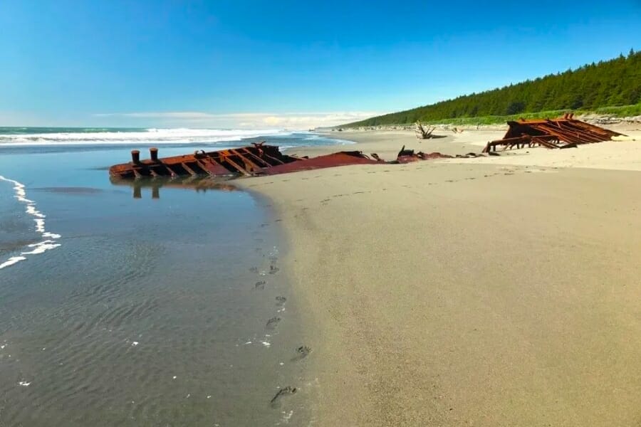 View of the wide stretch of white sand beach sand and waters of Salamatof Beach