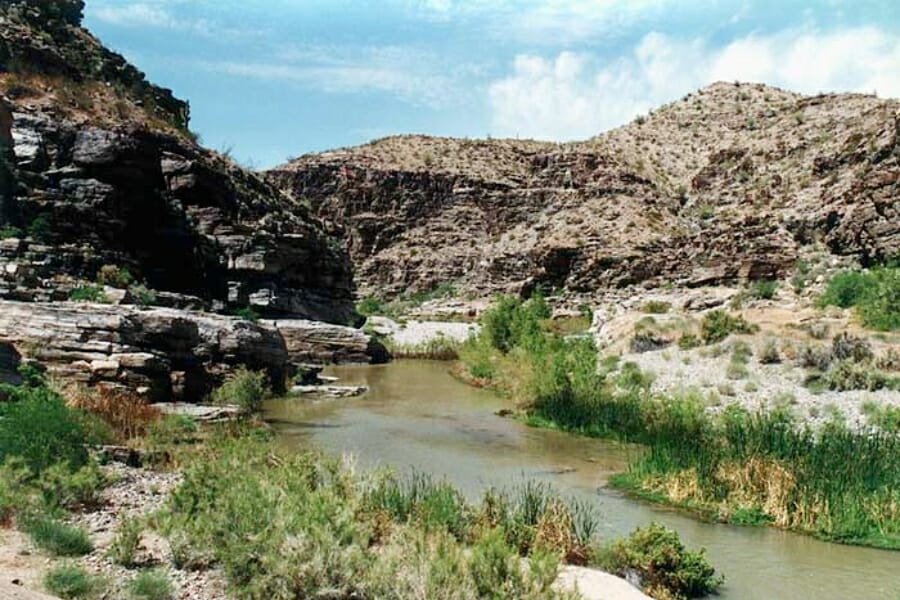 The Santa Maria River flowing between mountain ranges and green grasses