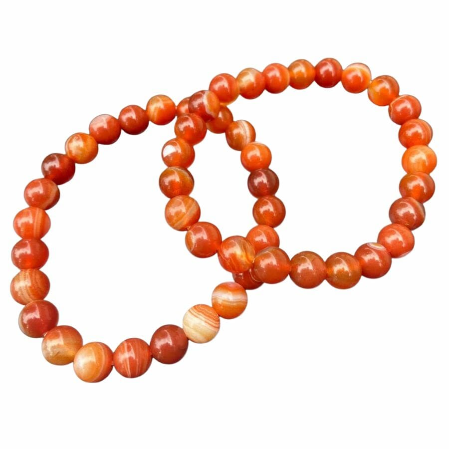 two bracelets with bright orange and white banded carnelian beads