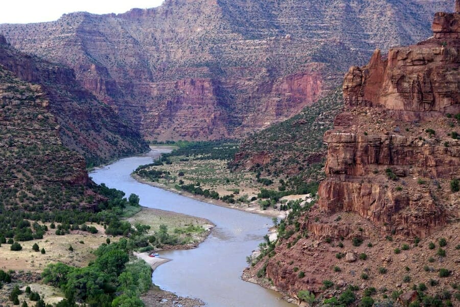 A gorgeous landscape of Desolation Canyon with a river flowing through the towering canyons