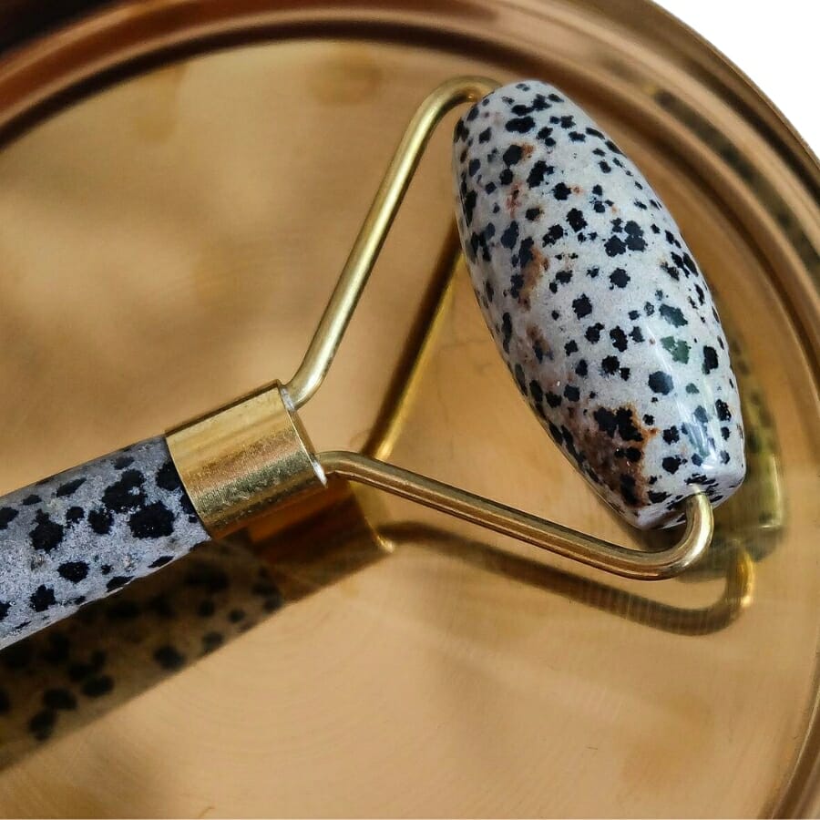 A facial roller made out of Dalmatian stone