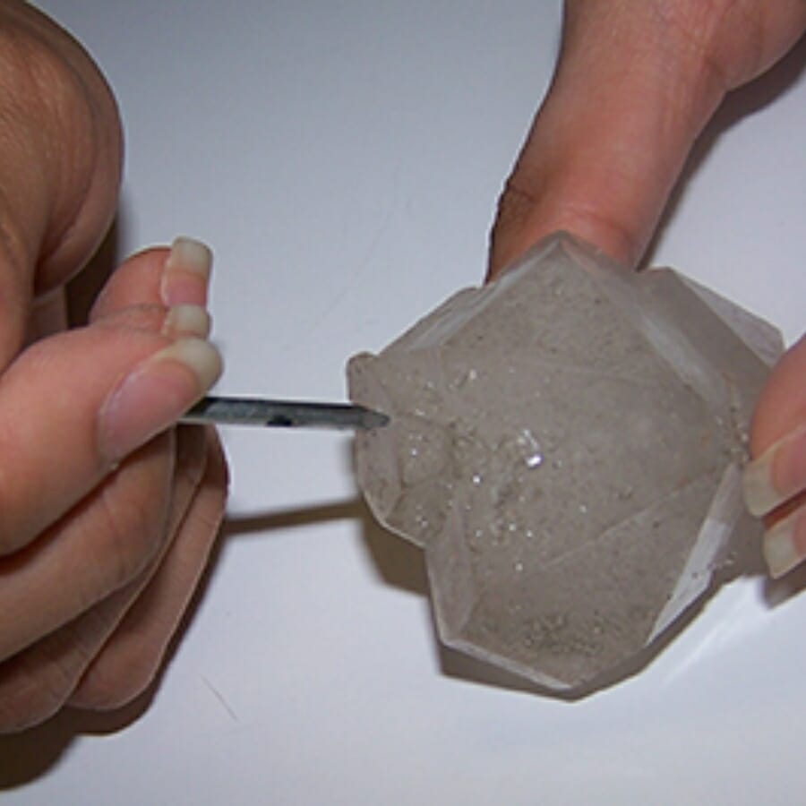 Performing a hardness test by poaching a crystal with a nail