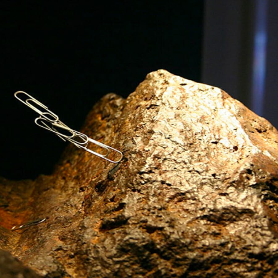 A rock attracting piles of metallic paper clips
