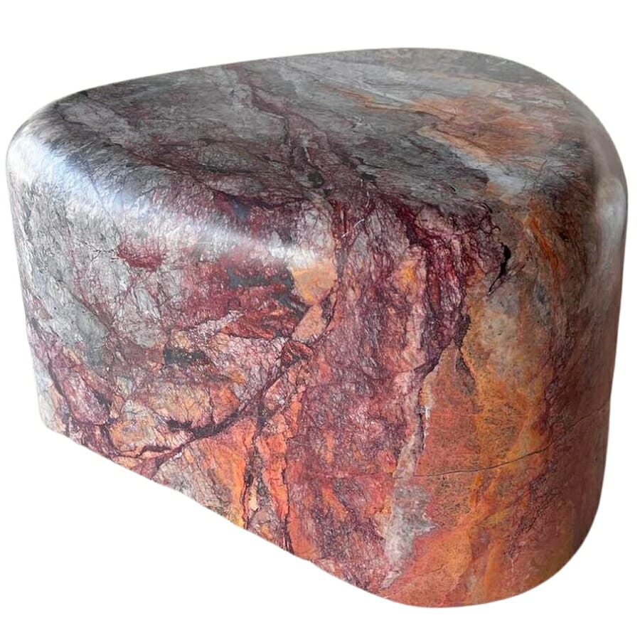 Polished piece of marble showing colors of orange, red, black, white, and brown