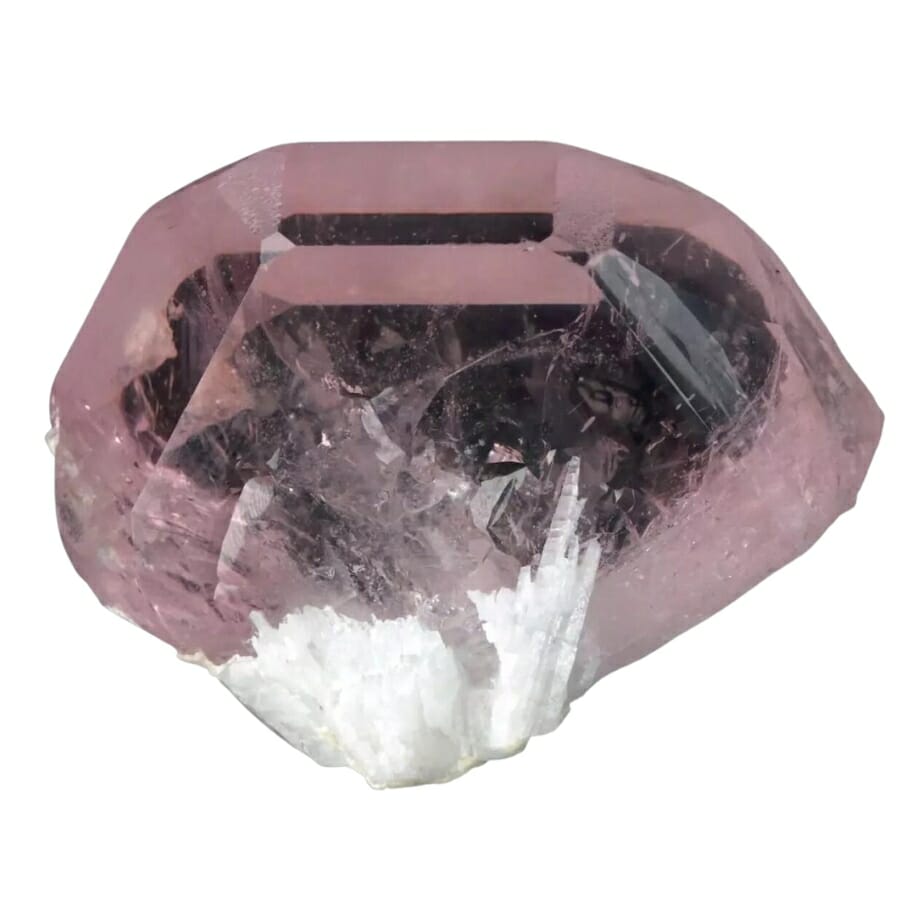 A distinct morganite specimen with white crystals underneath