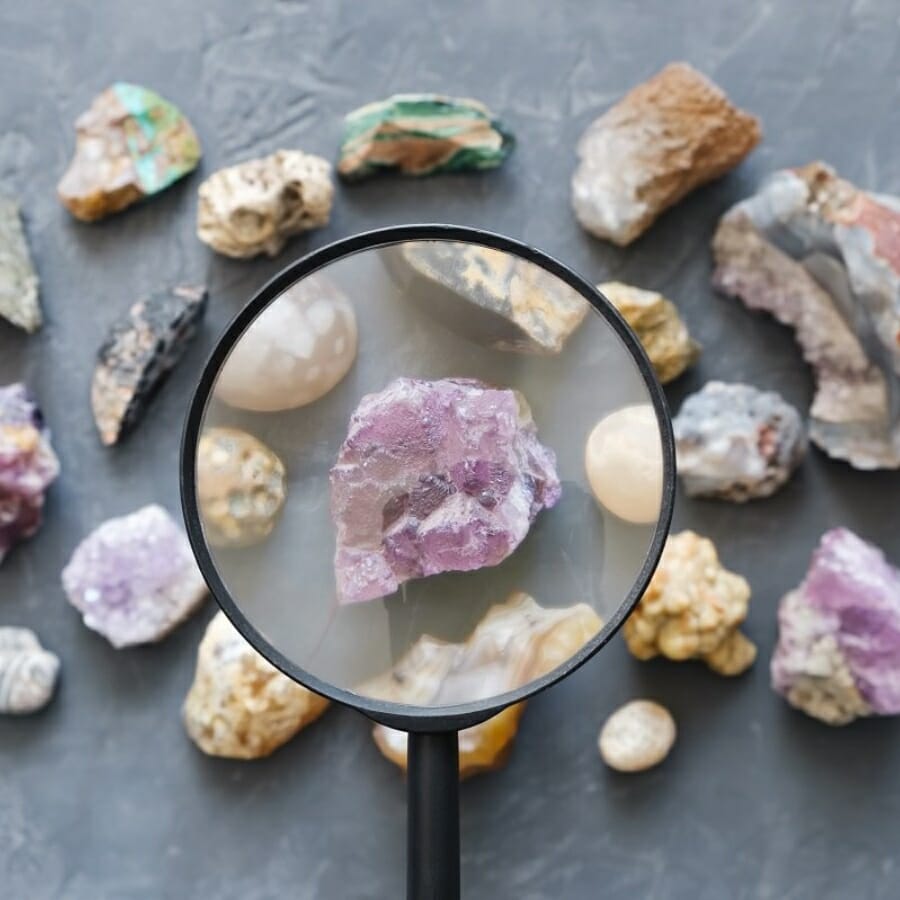 Examining the color and texture of a crystal with a magnifying glass