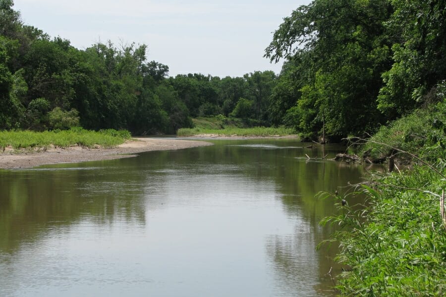 The Smoky Hill River surrounded by lush green forests where you can find agate specimens