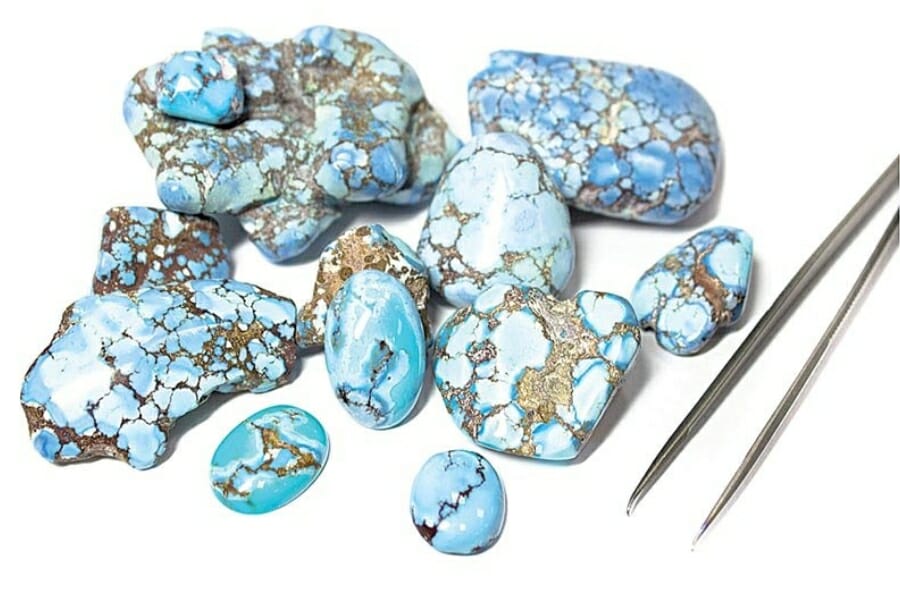 Appraising a handful of polished and raw turquoise stones