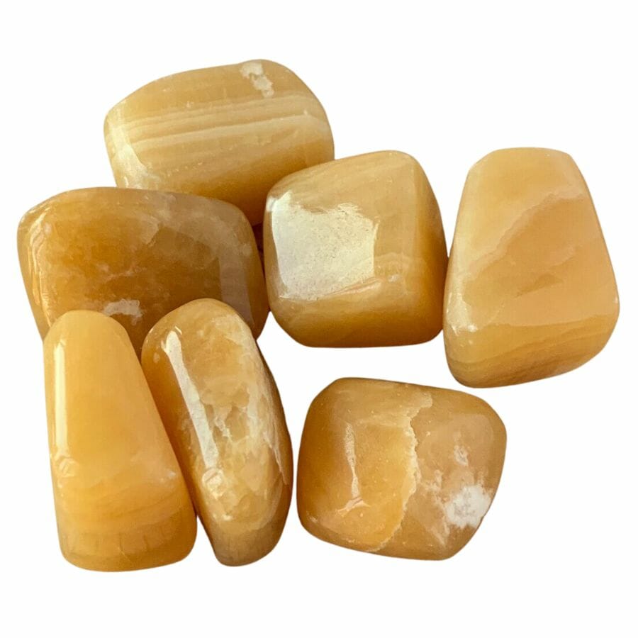 seven polished yellow calcite tumble stones
