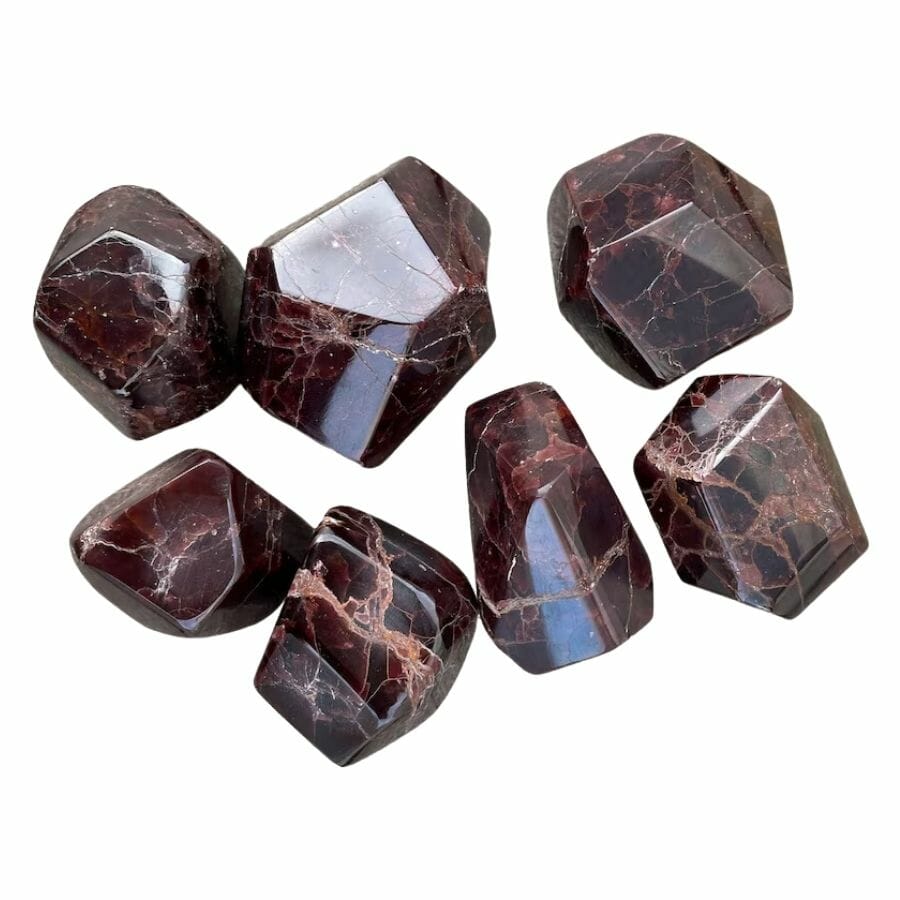 seven deep red polished garnet crystals