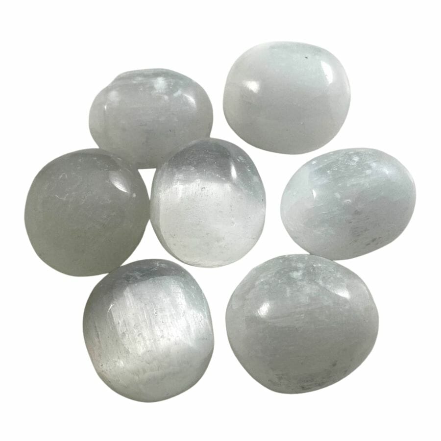 seven polished milky white satin spar stones