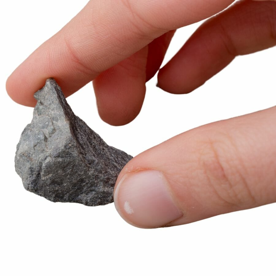hand holding a pebble between the thumb and forefinger