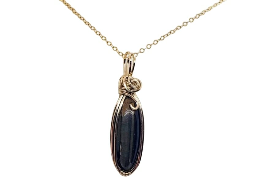 A simple but classy black tiger's eye necklace pendant with gold detail and chain