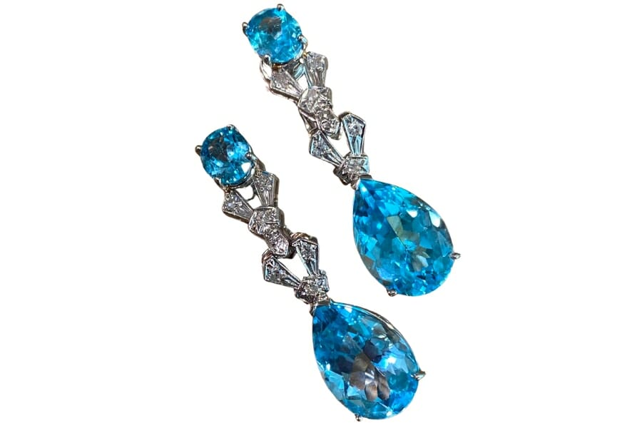 A set of dangling earrings with vibrant blue topaz