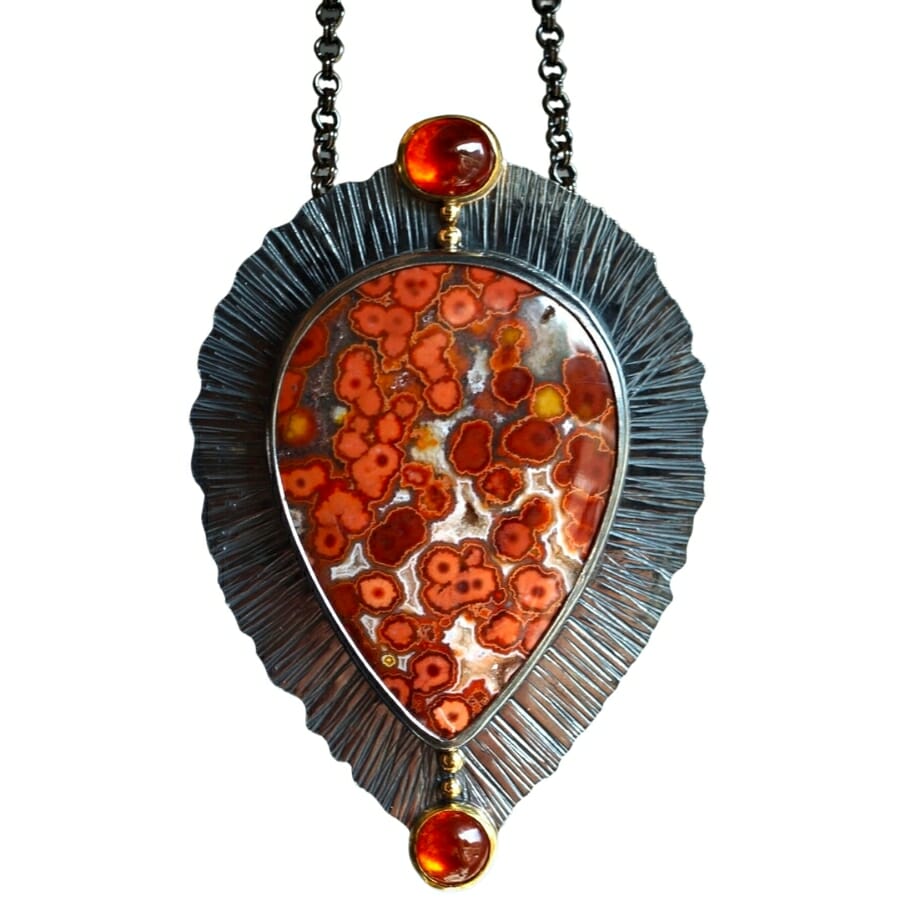 A pendant adorned with a river jasper and two small gem-grade spessartine garnets