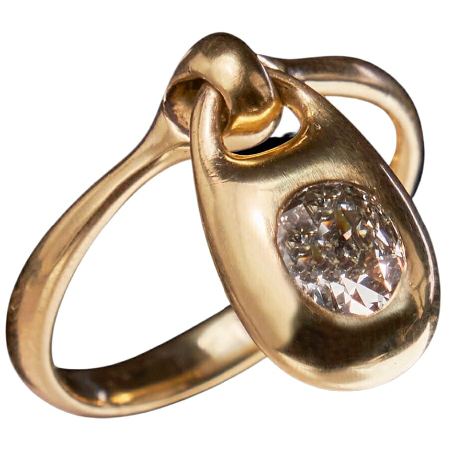 A locket charm ring adorned with a lustrous diamond
