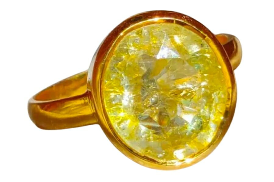 A sparkling round yellow topaz set as center stone in a golden ring