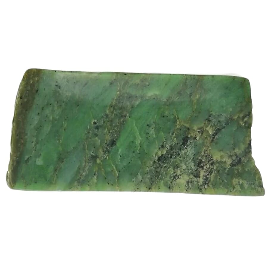 A raw jade slab with black spots and streaks