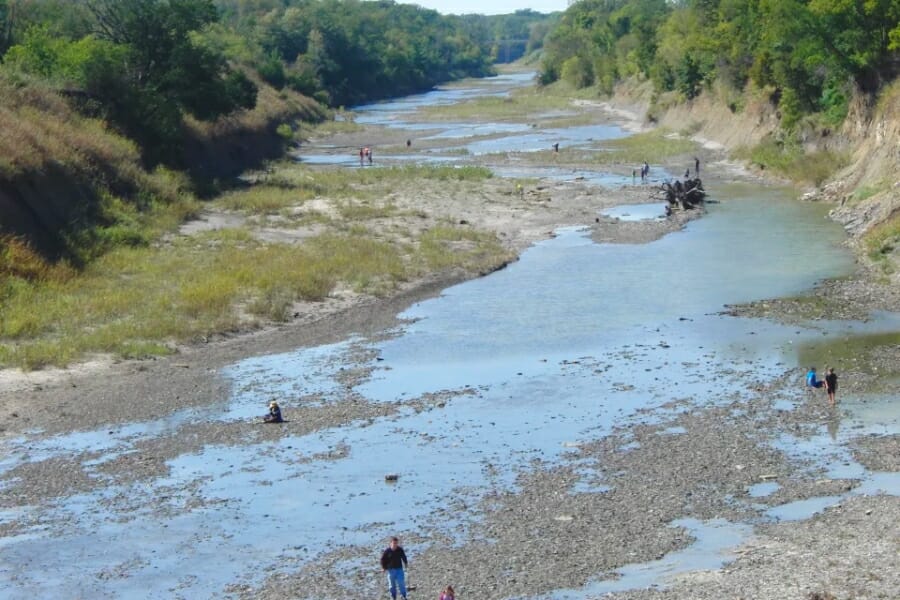 Aerial view of the Ladonia Fossil Park's riverbed with people of different ages who are searching for fossils