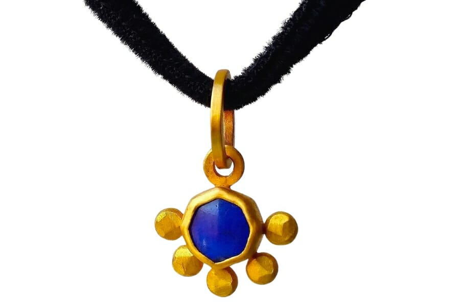 Cute golden pendant with a deep blue lapis lazuli as center stone