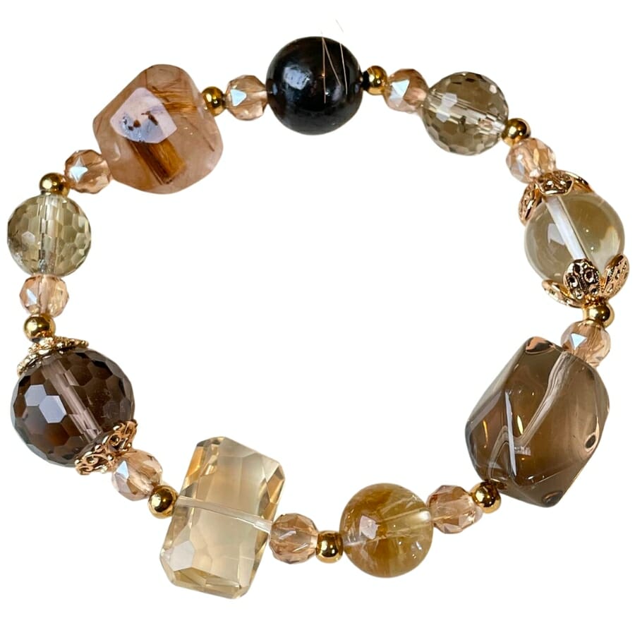 A bracelet made out of rutilated quartz and smoky quartz with other gemstones