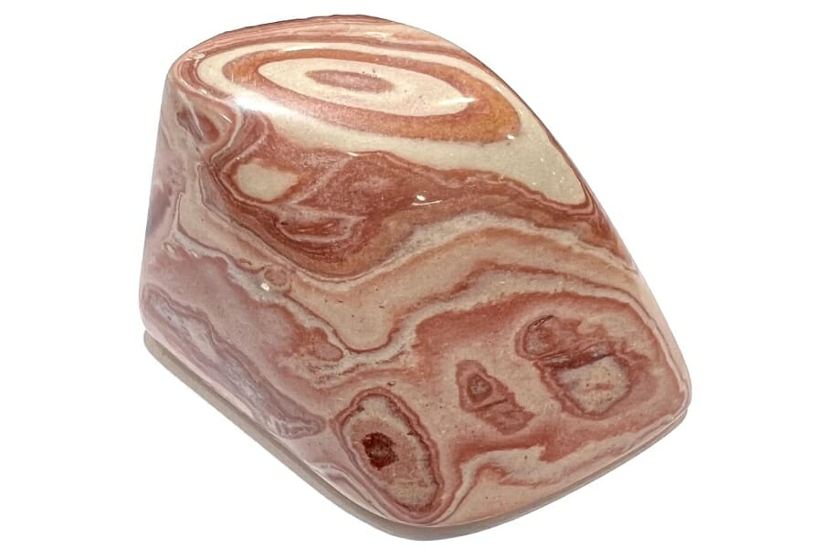 The intricate bands and swirls of a polished Picture Jasper with pink, brown, and beige hues