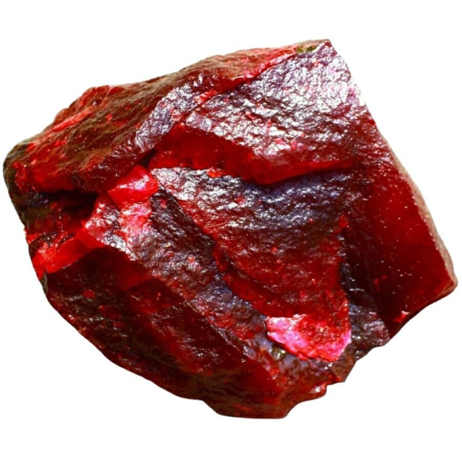 A bright red raw ruby with a prevalent texture on its surface