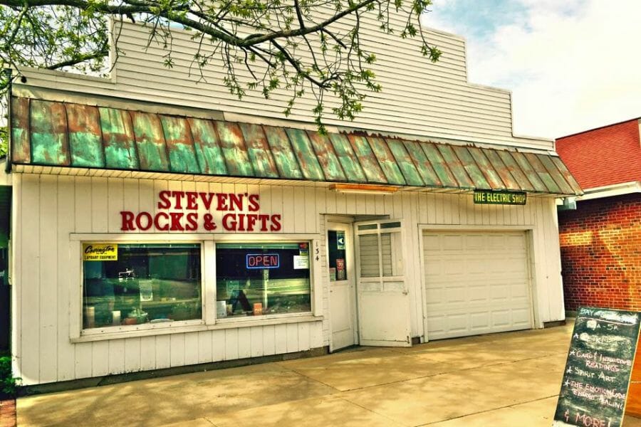 exterior of white building with a sign that says "Steven's Rocks & Gifts"