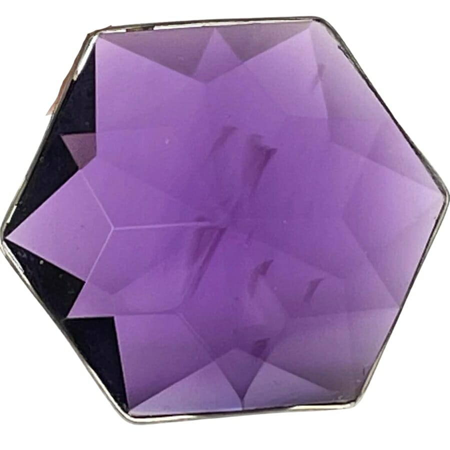A hexagonal-shaped purple synthetic amethyst with a beautiful pattern