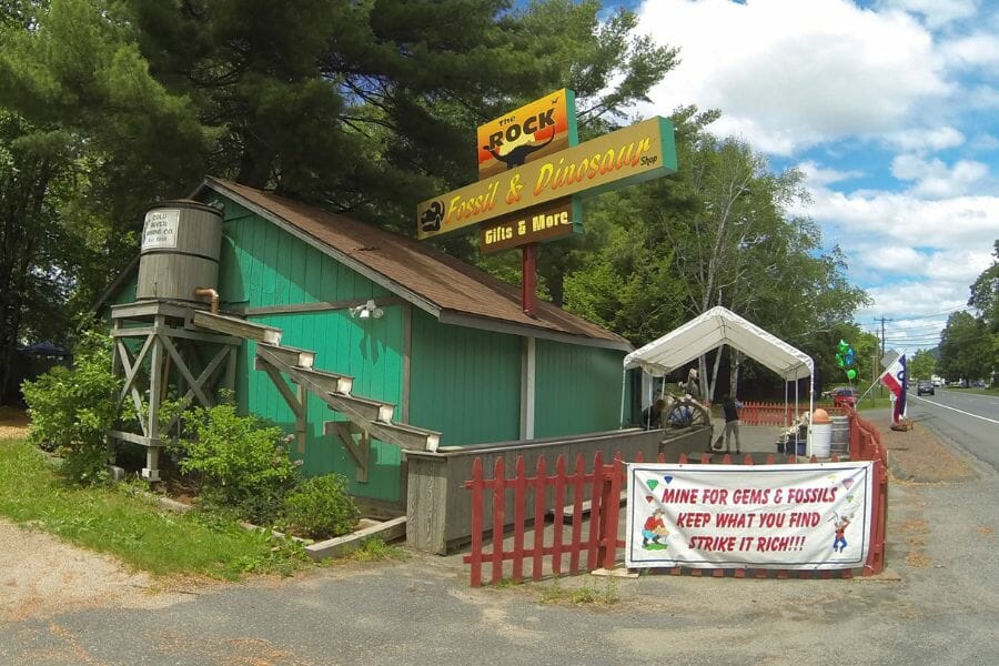 green building with a sign for The Rock Fossil and Dinosaur Shop