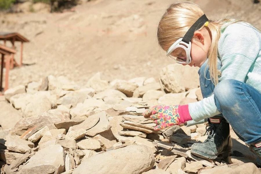 girl with goggles looking at rocks at the Stonerose Interpretive Center