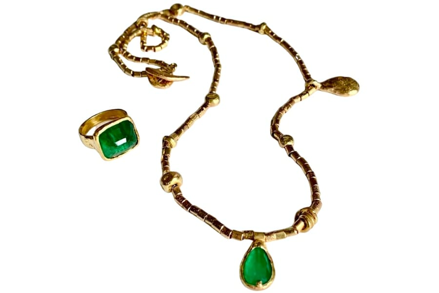 Gold necklace and ring adorned with beautiful yellow-green emeralds