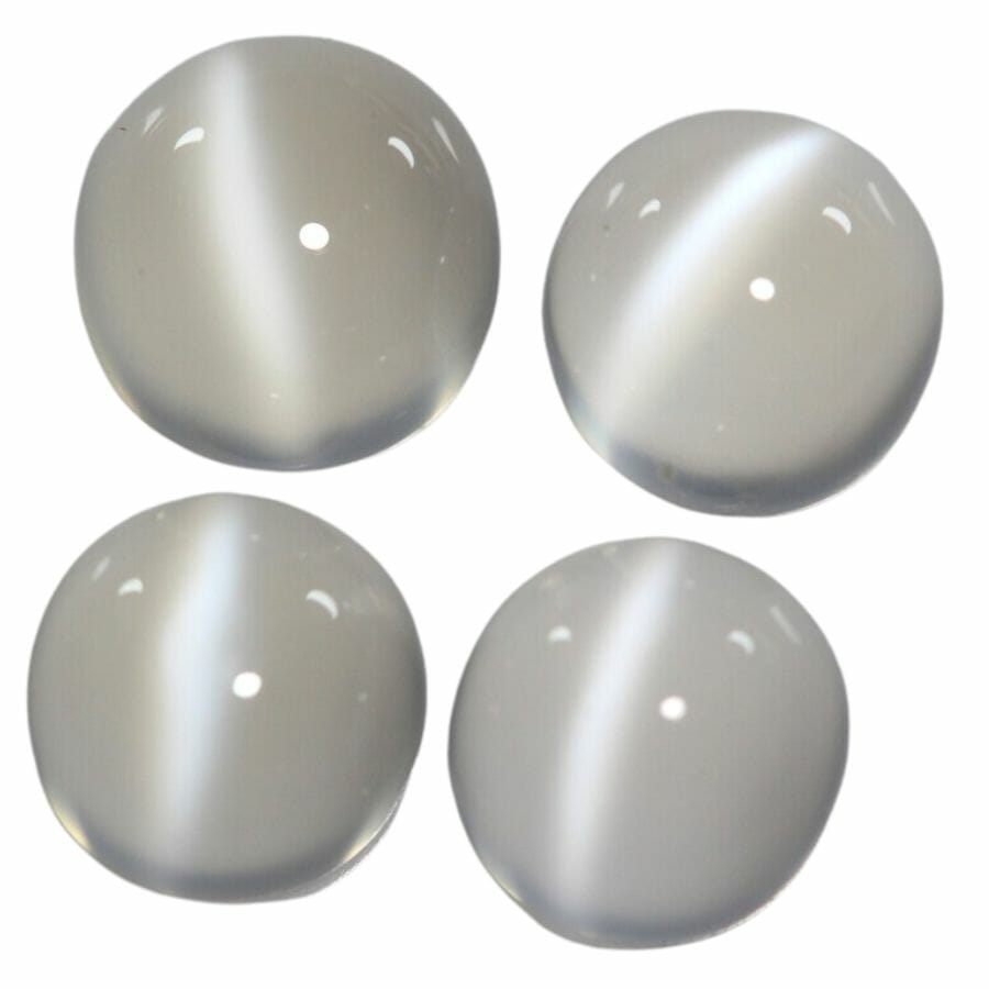 four round white moonstone cabochons with cat's eye effect