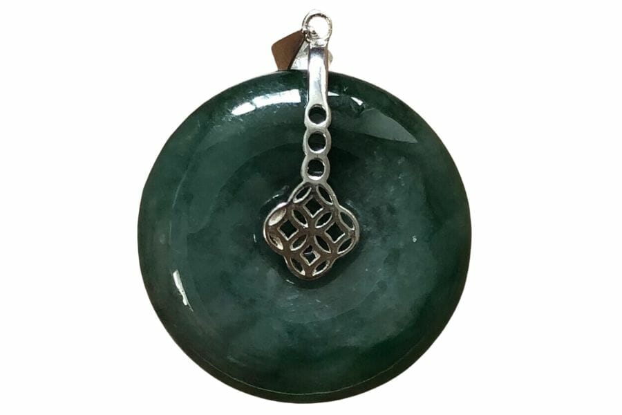 round deep green donut jadeite pendant in a silver setting